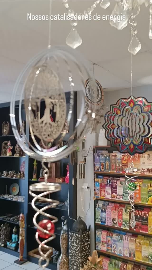Catalisadores de energia de metal com a árvore da vida girando no teto da loja, com prateleiras de incensos ao fundo